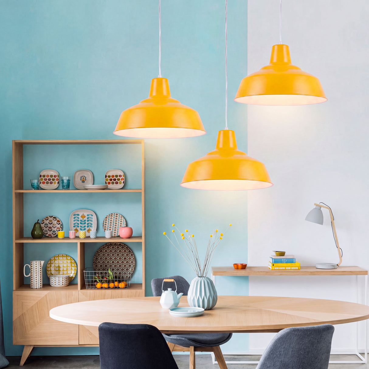Juego de tres campanas amarillas que crean un contraste estético y aportan luz difusa sobre mesa de madera.