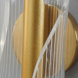 Primer plano del acabado dorado y la textura lineal del acrílico de la lámpara de pared Vortex Gold.
