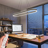 Escritorio de oficina iluminado con lámpara colgante LED ovalada de luz blanca.