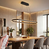 Lámpara de techo ovalada suspendida sobre mesa de comedor de madera elegante.