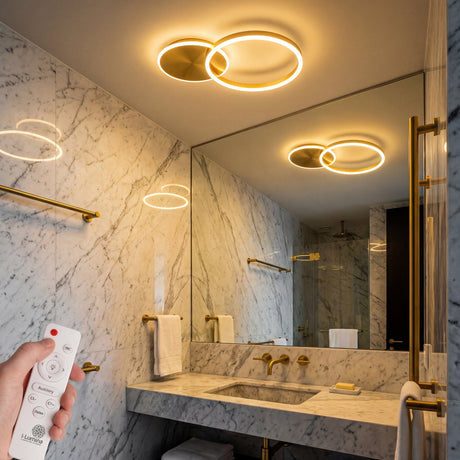Plafón LED circular dorado instalado en techo de baño con diseño de lujo.
