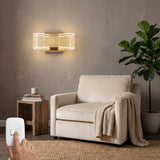 Aplique Cubic Gold instalado sobre un sillón blanco en una sala moderna, aportando una luz ambiental sofisticada.