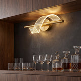 Aplicacion decorativa horizontal de la lampara Helix Gold iluminando una zona de bar con copas y botellas.
