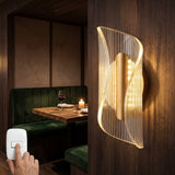 Aplique de pared Vortex Gold iluminando una mesa de restaurante con acabados en madera y terciopelo verde.