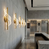 Pared decorada con varias luminarias Helix Gold en posicion vertical creando un patron de luz moderno.