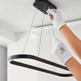 Instalación de lámpara con cables tensores ajustables y base de techo negra.