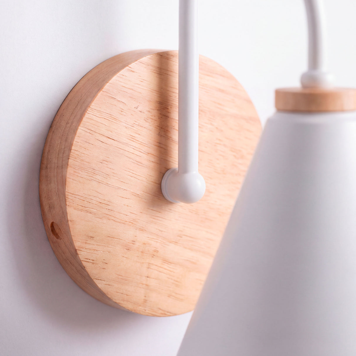 Detalle en primer plano de florón en madera natural y chasis blanco con diseño minimalista.