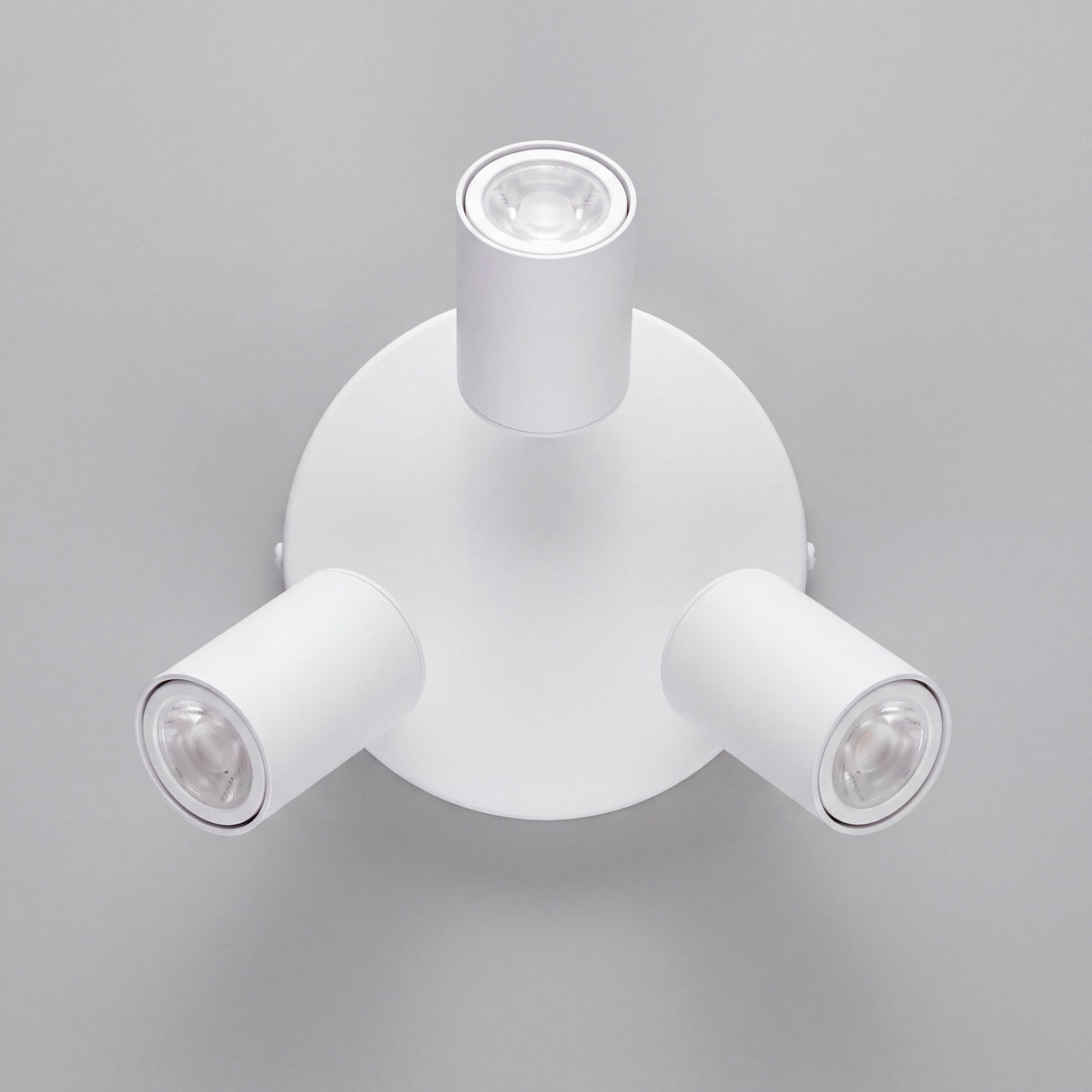 Vista cenital de tres reflectores orientables con acabados premium en pintura electrostática blanca.