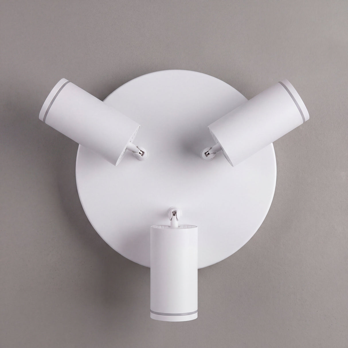Vista cenital de tres reflectores orientables con acabados premium en pintura electrostática blanca.