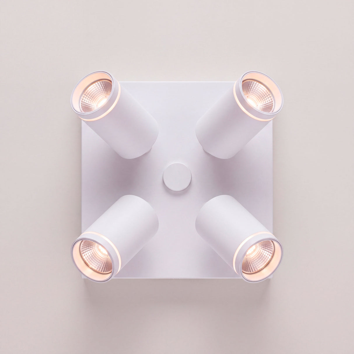 Vista cenital de cuatro reflectores orientables con acabados premium en pintura electrostática blanca.