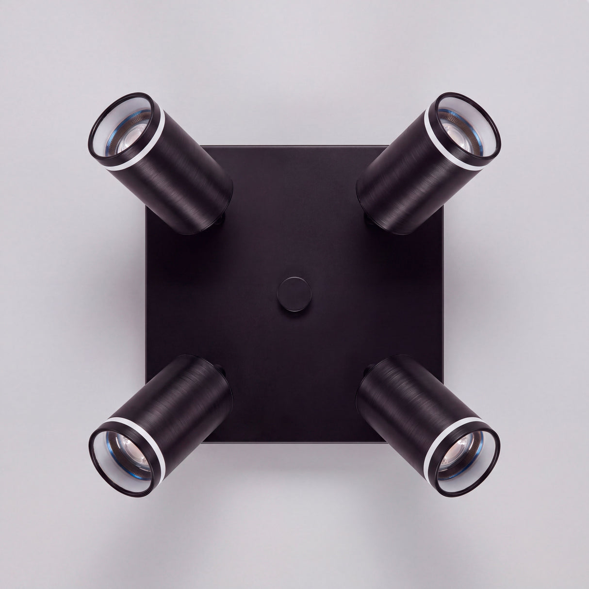 Vista cenital de cuatro reflectores orientables con acabados premium en pintura electrostática negra.