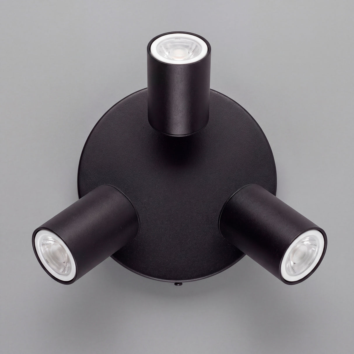 Vista cenital de tres reflectores orientables con acabados premium en pintura electrostática negra.