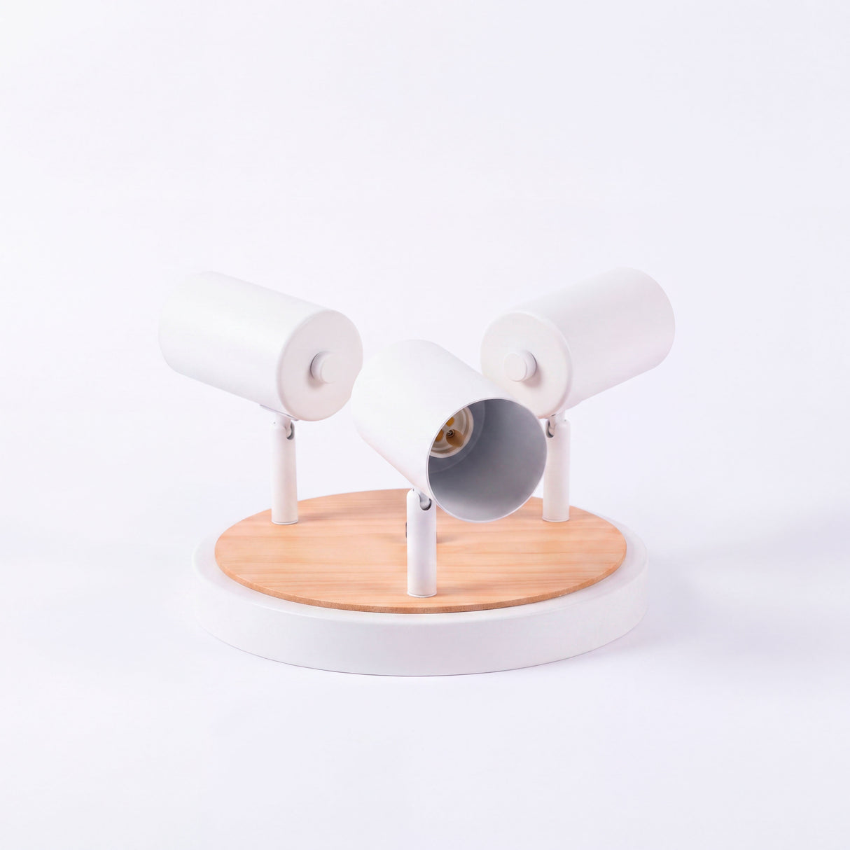 Presentación de chasis circular en blanco mate con cabezales cilíndricos y base de madera natural.