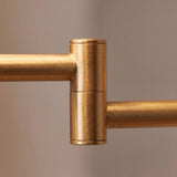 Detalle de la bisagra giratoria del brazo dorado del aplique articulable