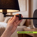 Mano moviendo el brazo articulable del aplique de pared GALA