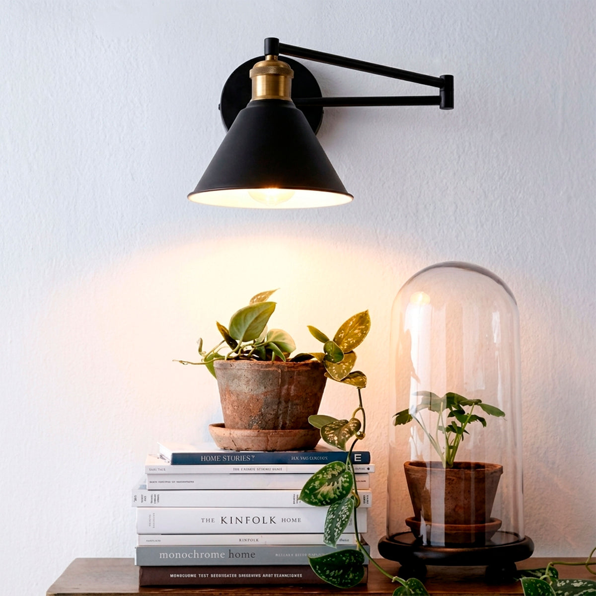 Aplique de pared con brazo extensible en negro y dorado mate para proyectos de iluminación técnica.