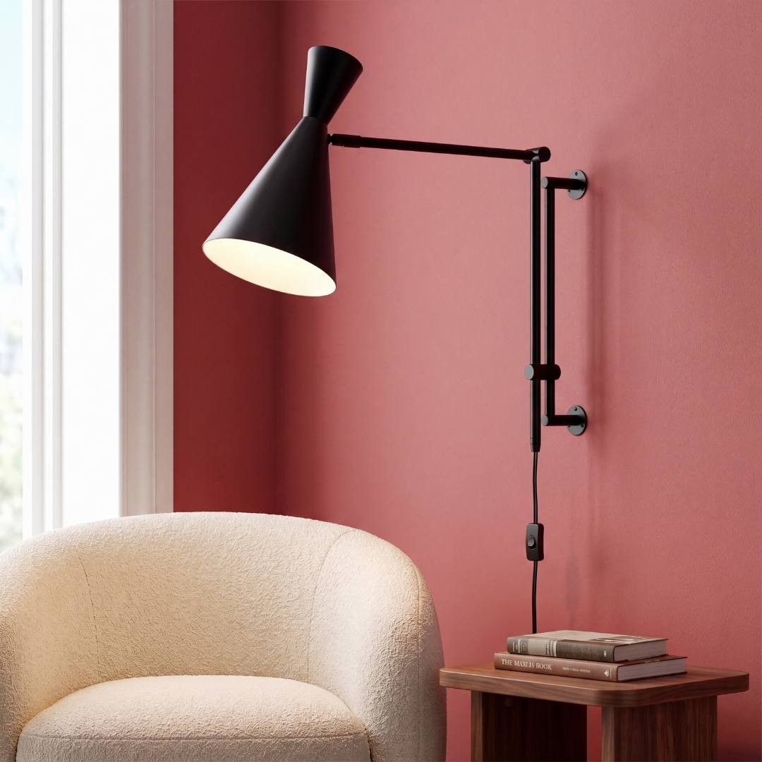 Aplique de pared articulable IRIS negro mate sobre sillón de lectura bouclé