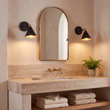 Apliques de pared BRERA negros iluminando un baño con espejo en arco