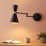 Aplique de pared negro y dorado CAPRI con brazo extendido iluminando un escritorio