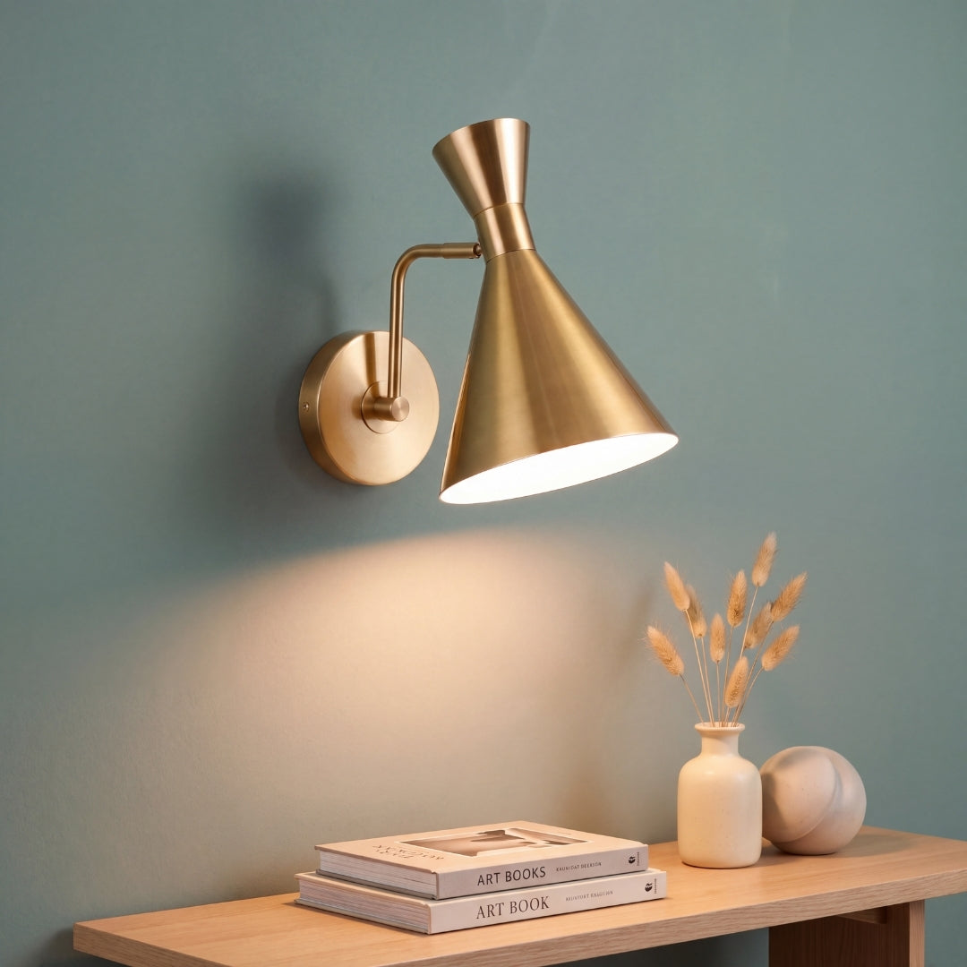 Aplique de pared dorado CAPRI GOLD encendido con luz cálida sobre consola decorativa