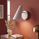 Aplique de pared LENA blanco encendido sobre muro rojo ladrillo con consola decorada
