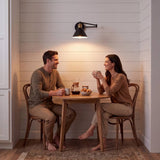 Pareja compartiendo en la mesa bajo la luz cálida del aplique ELSA