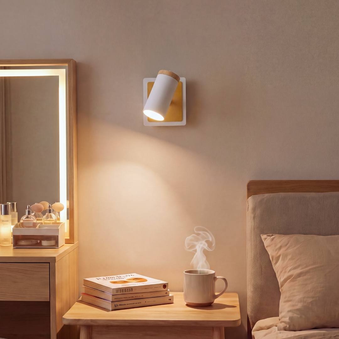 Aplique de pared blanco encendido con luz cálida sobre un tocador