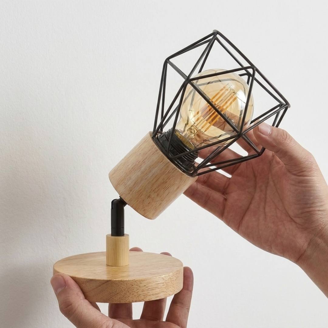 Mano enroscando un foco E27 en el cabezal de madera del aplique, foco no incluido