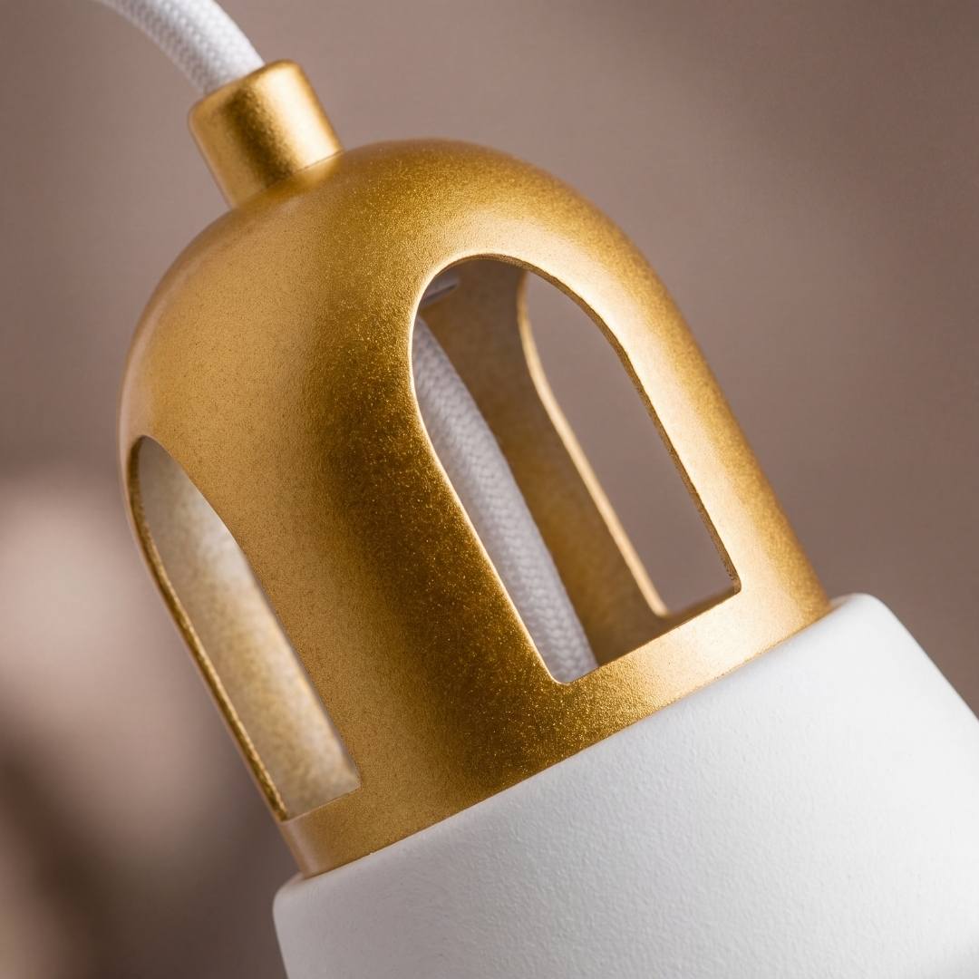 Detalle del portasocket dorado calado y la campana blanca del aplique SOHO