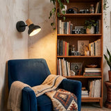 Aplique de pared con luz cálida en rincón de lectura con sillón