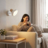 Aplique de pared blanco iluminando sala con persona leyendo