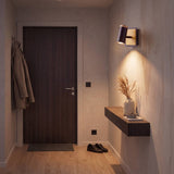 Aplique decorativo iluminando un pasillo moderno con repisa de madera