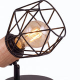 Detalle de la jaula geométrica negra con soporte de madera natural