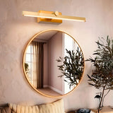 Lámpara Natalia Old Brass de 12W instalada sobre espejo circular en baño elegante.