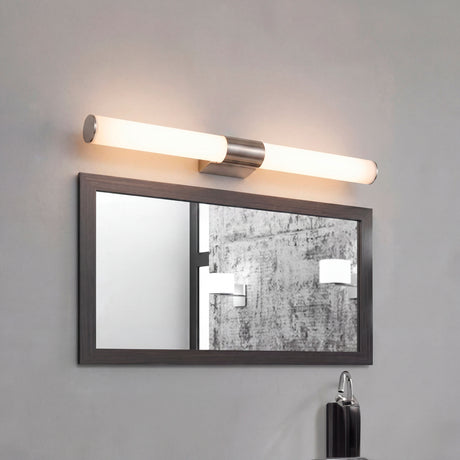 Lámpara de pared cilíndrica Nery Silver de 12W sobre espejo con marco negro.