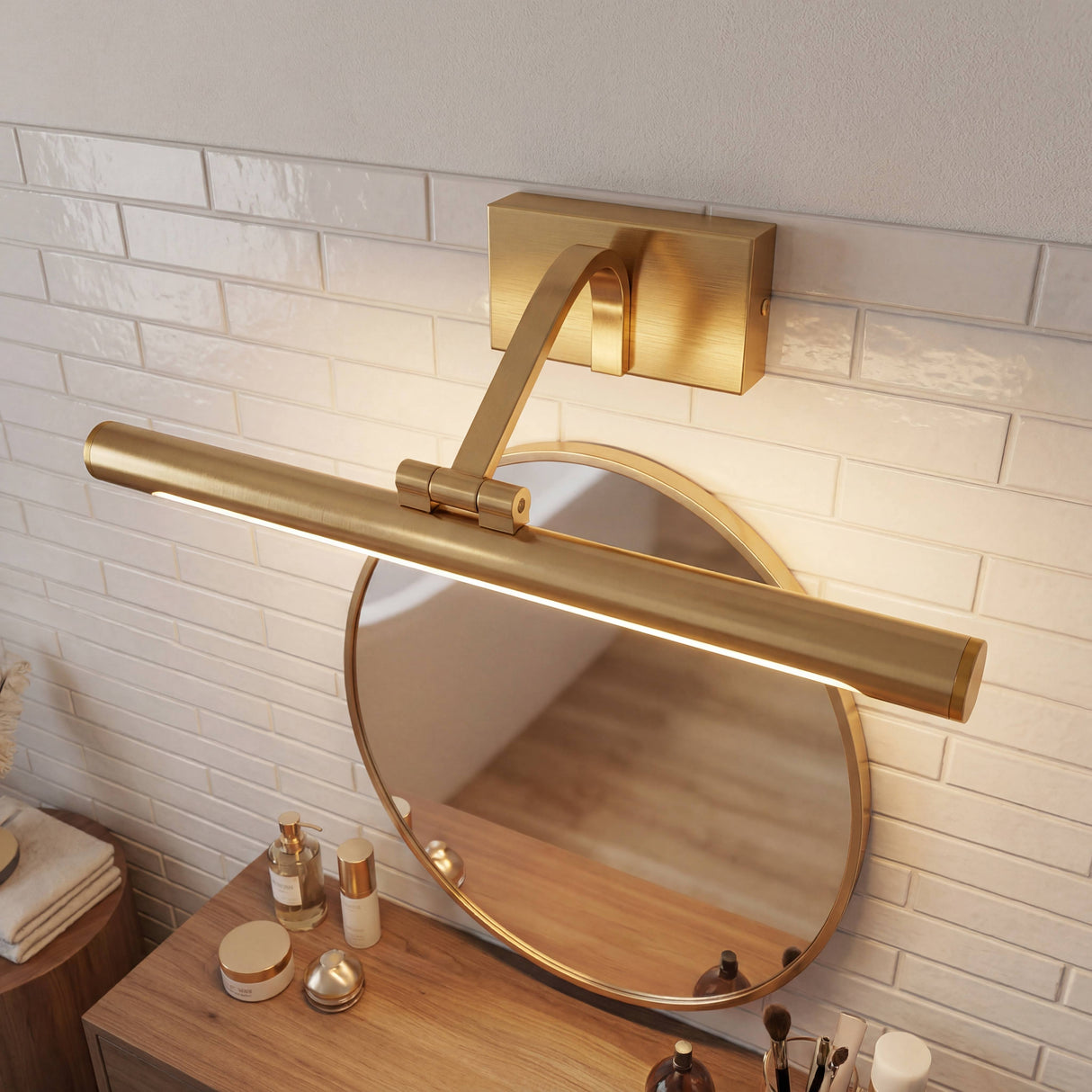 Montaje superior de lámpara dorada sobre espejo de baño con azulejos tipo metro e iluminación de acento.