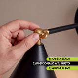 Mano aflojando la llave de la rótula para orientar el cabezal del aplique BRERA