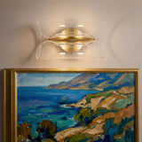 Aplique de pared moderno instalado de forma horizontal iluminando un cuadro artístico.