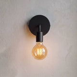 Aplique con foco vintage encendido proyectando luz cálida