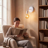 Aplique iluminando a mujer leyendo junto a la ventana