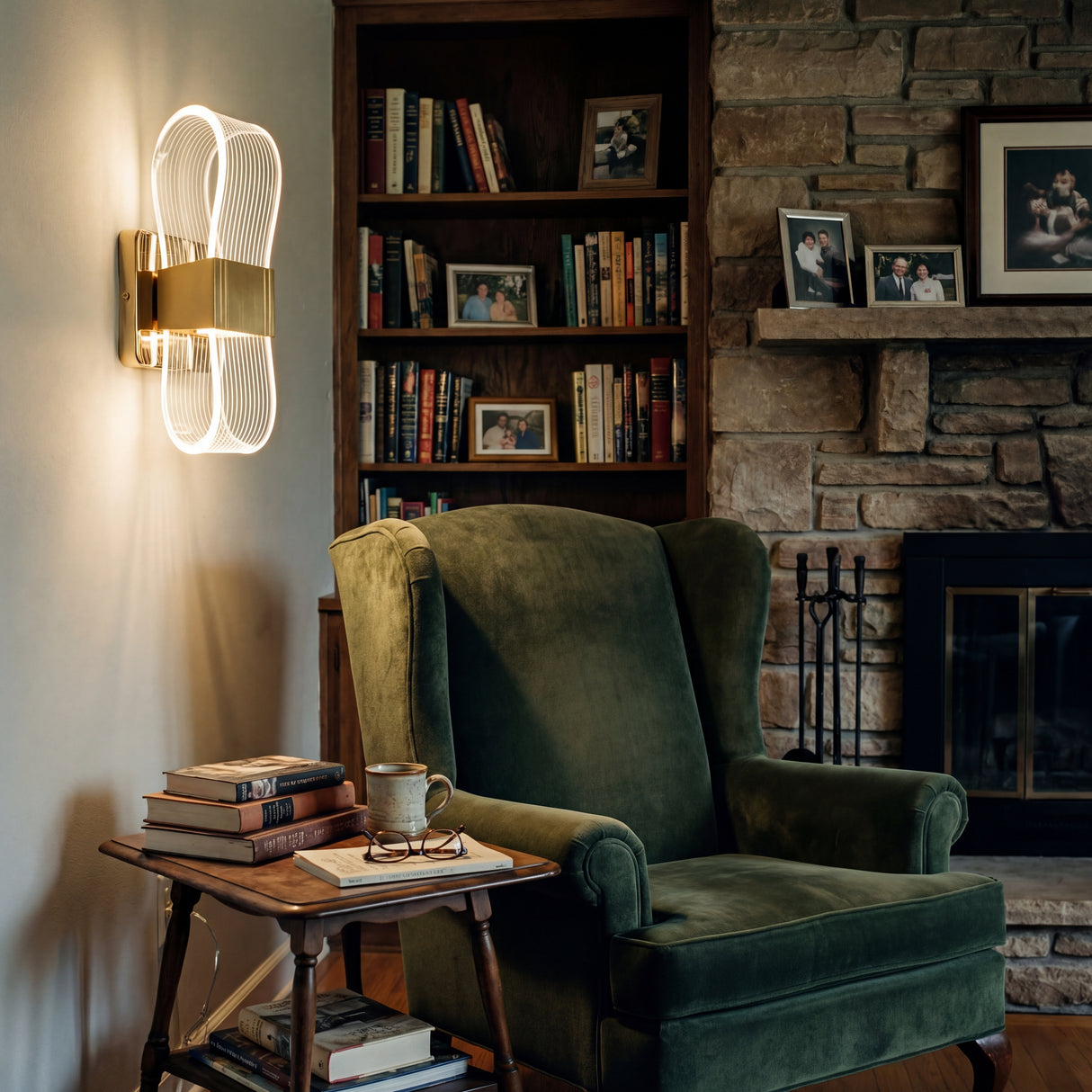 Aplique de pared moderno Flow Gold iluminando un rincon de lectura con sillon verde.