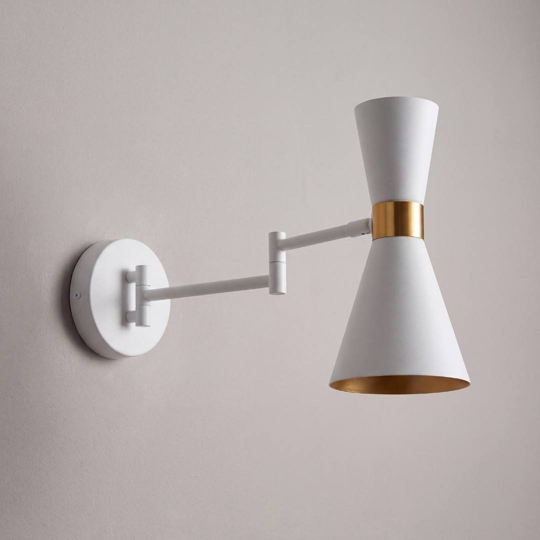 Aplique de velador blanco encendido con luz cálida junto a la cama