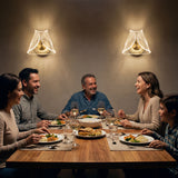 Dos lámparas Pyramid Gold en posición vertical iluminando una cena familiar en el comedor.