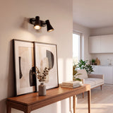 Puntos de luz de acento direccionados hacia credenza en salón de diseño minimalista.