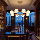 Barra de bar elegante con la lampara Collier Gold creando una atmosfera sofisticada con luz calida nocturna.