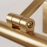 Detalle técnico de la rótula dorada con tornillo de fijación para regular la inclinación del haz de luz.
