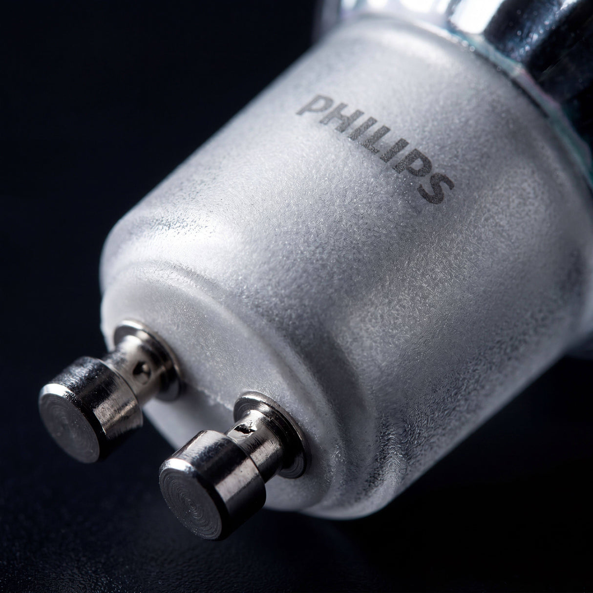 Detalle técnico del conector bi-pin texturizado para instalación rápida en portalamparas empotrables.