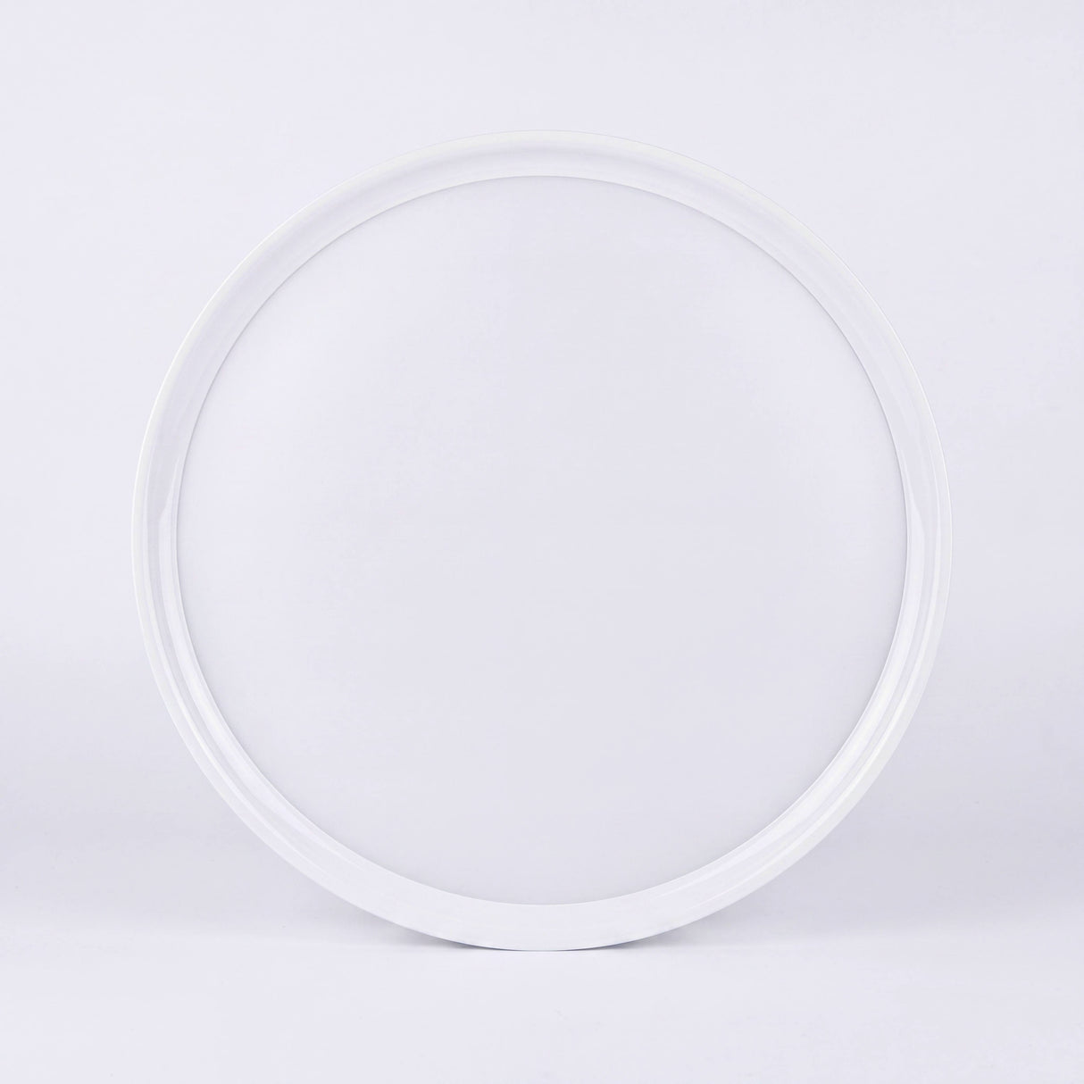 Plafón circular adosable en techo blanco aportando una distribución difusa y limpia en arquitectura contemporánea.