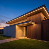 Fachada moderna con alero iluminado por cinta LED COB luz cálida al atardecer