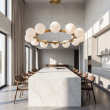 Mesa de comedor de marmol blanco en ambiente moderno iluminada por la lampara Collier Gold de 12 luces.